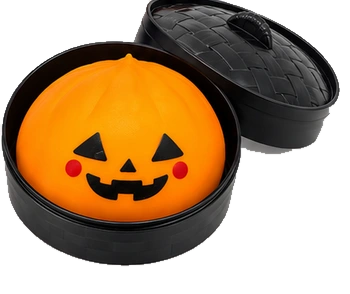 Orange pumpkin dumpling squishy in its black container